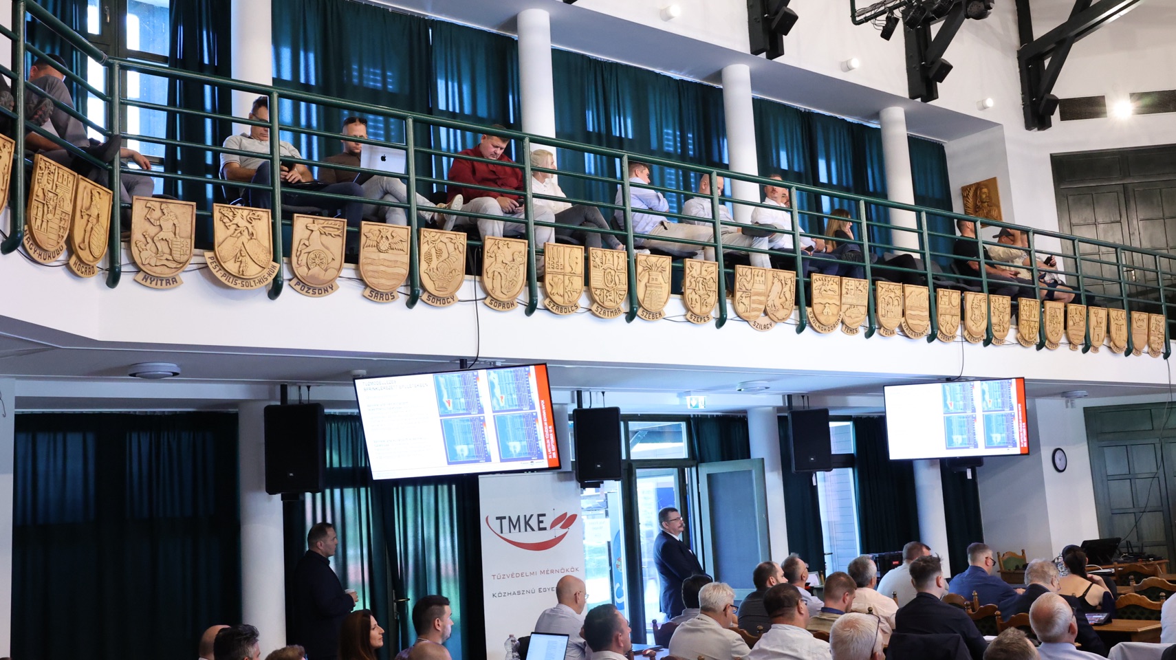 A konferenciaterem karzata és résztvevői.